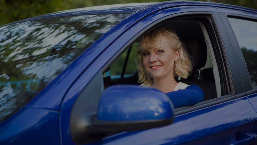 A learner driver smiling from the driver’s seat