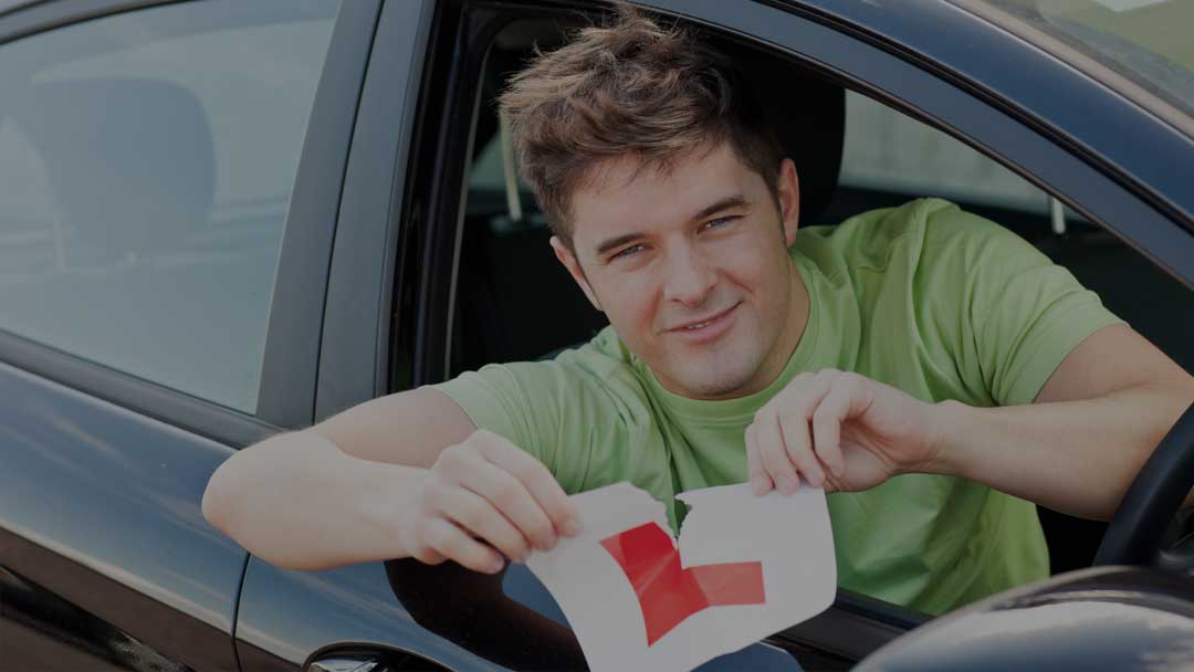 A newly qualified driver tearing an L-plate in half
